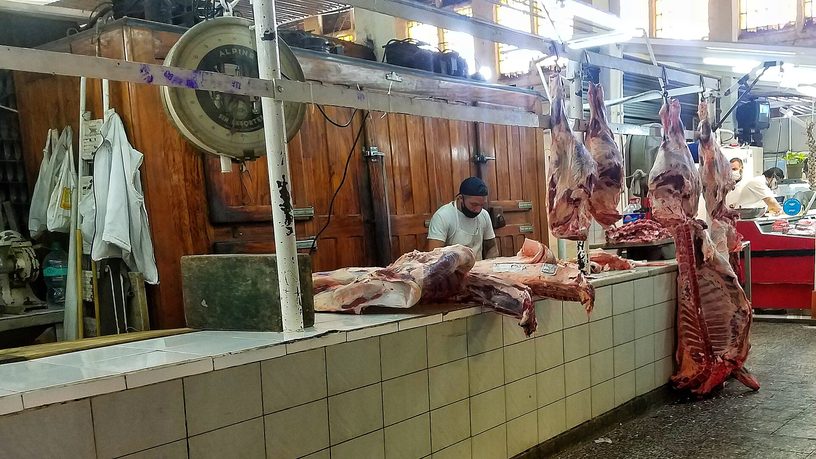 Un carnicero despunta una media res en un puesto del mercado Vélez Sársfield, en Buenos Aires.