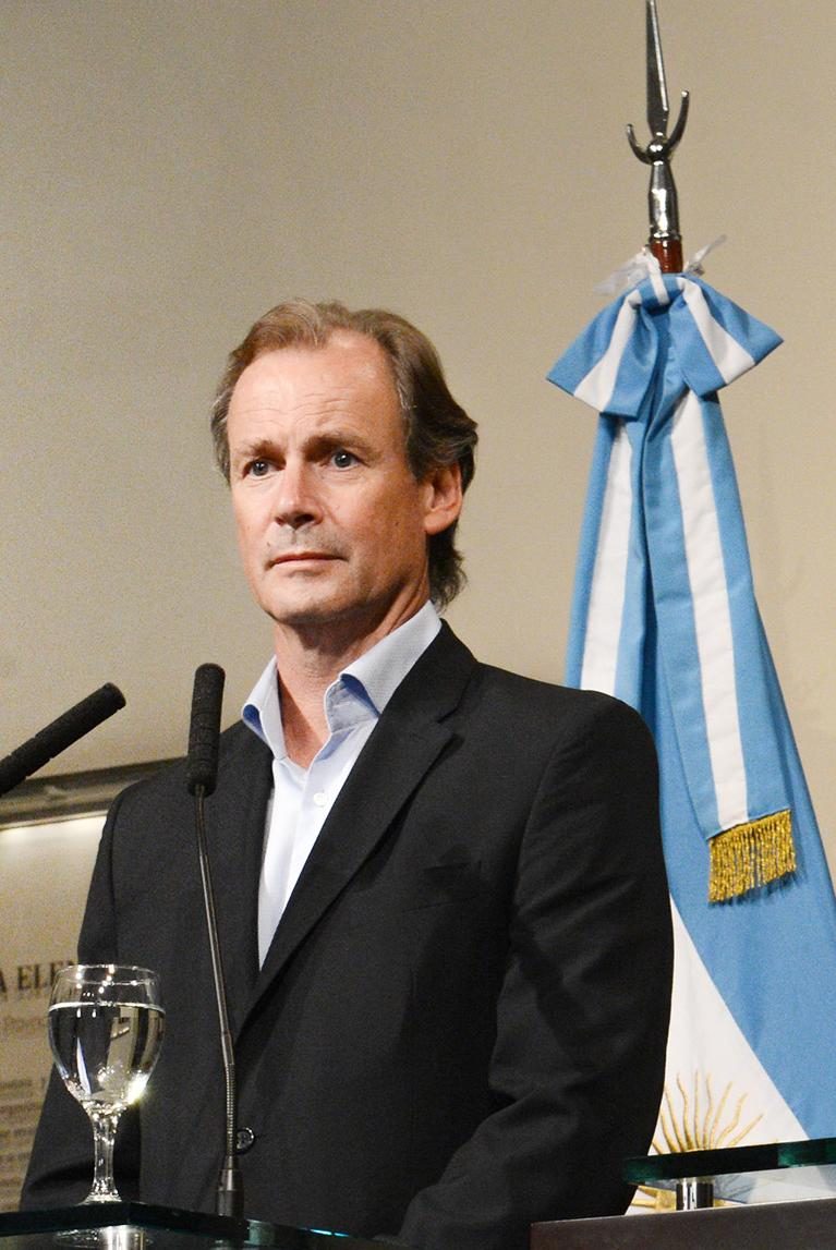 Gustavo Bordet ante los micrófonos, junto a una bandera argentina, en enero de 2016, cuando era gobernador de Entre Ríos.